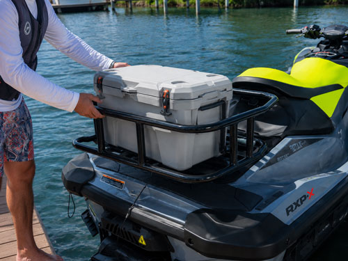 Person loading a cooler onto the Orcapak GateOr rack on a Sea-Doo jet ski
